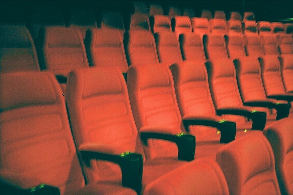 a row of empty red seats in a theater